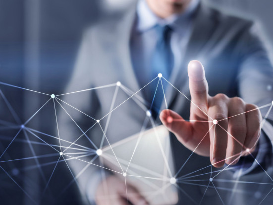 Geschäftsmann in Anzug berührt ein digitales Netzwerk mit dem Finger.
